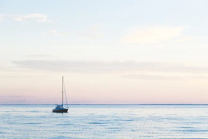 Fototapeta: Żaglówka pływająca na morzu przy zachodzie słońca