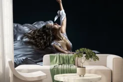 Fototapeta: Beautiful brunette girl with curly hair in the darkness and light