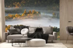 Fototapeta: Dreamy panoramic misty landscape with trees poking our of foggy