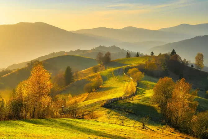 Fototapeta: Jesienny krajobraz z górami o wschodzie słońca