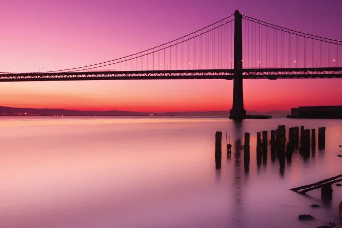 Fototapeta: Krajobraz z zachodem słońca i mostem na tle różowego nieba