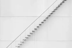 Fototapeta: Metalowe delikatne schody przy białej ścianie