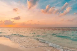 Fototapeta: Morskie fale wypływające na plażę o wschodzie