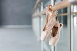 Fototapeta: Różowe pointy na drążku do ćwiczeń w sali baletowej