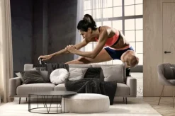 Fototapeta: Sport. kobieta na siłowni robi ćwiczenia rozciągające i uśmiecha