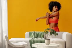 Fototapeta: Young fit black woman in sportswear posing isolated on yellow