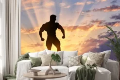 Naklejka: Sylwetka kulturysty stwarza na zachodzie słońca