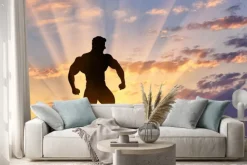 Naklejka: Sylwetka kulturysty stwarza na zachodzie słońca