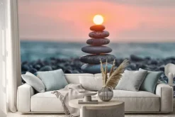 Naklejka: Wieża z gładkich kamieni na plaży o zachodzie słońca