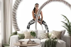 Naklejka: Woman doing exercises with battle rope. photo of muscular model