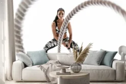 Naklejka: Woman doing exercises with battle rope. photo of muscular model