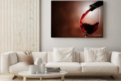 Obraz: Czerwone wino leje w szkle na tle