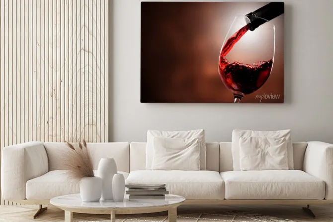 Obraz: Czerwone wino leje w szkle na tle