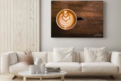 Obraz: Kubek gorącego cappucino stoi na drewnianym stole.