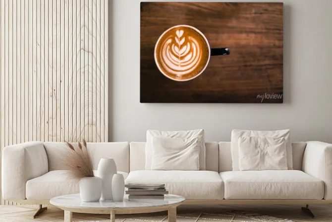 Obraz: Kubek gorącego cappucino stoi na drewnianym stole.