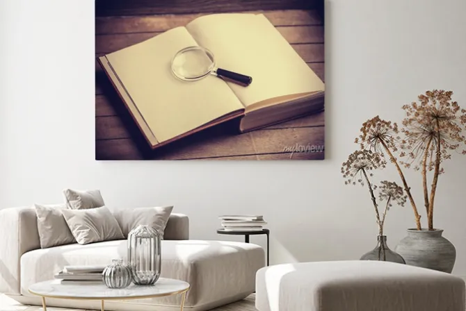 Obraz: Loupa i książka na drewnianym stole