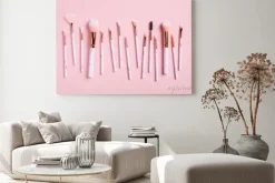Obraz: Professional makeup brushes kit on pink background top view.