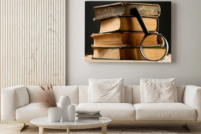 Obraz: Stos starych książek z lupą