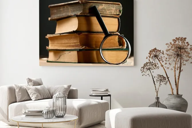 Obraz: Stos starych książek z lupą