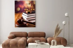 Obraz: Waga temidy i młotek sędziego na książkach