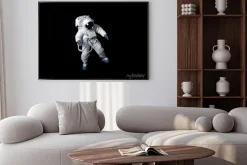 Plakat: Astronauta pływających na czarnym tle.