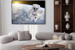 Plakat: Astronauta w przestrzeni, w tle nasz ziem słońce - elementy tego