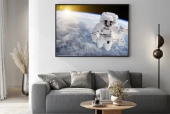 Plakat: Astronauta w przestrzeni, w tle nasz ziem słońce - elementy tego