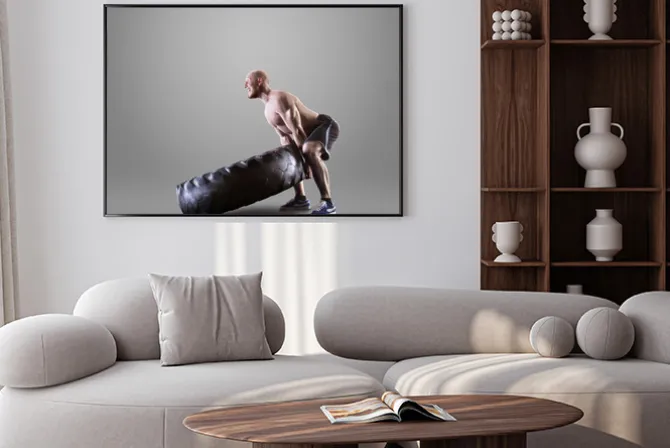 Plakat: Athletic młody człowiek podnoszenia oponę na szarym tle studio