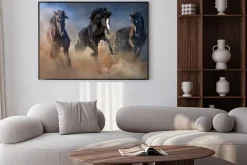 Plakat: Czarne ogiery biegną galopem w pustynnym pyle przed dramatycznym