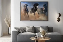 Plakat: Czarne ogiery biegną galopem w pustynnym pyle przed dramatycznym