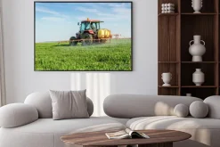 Plakat: Farmer rozpylanie zielonym polu pszenicy