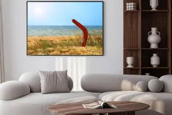 Plakat: Krajobraz z bumerang na zarośniętej piaszczystej plaży.