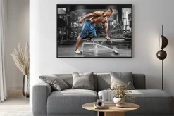 Plakat: Muskularny mężczyzna pracy w siłowni robi ćwiczenia z hantlami