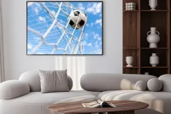 Plakat: Piłka w siatce bramki na tle nieba