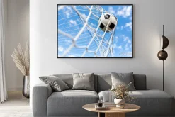 Plakat: Piłka w siatce bramki na tle nieba