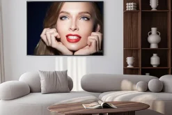 Plakat: Piękna dziewczyna z czerwonymi ustami z rękami w pobliżu twarzy