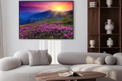 Plakat: Różowe kwiaty na tle gór w zachodzącym słońcu