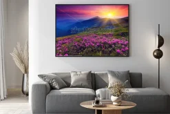 Plakat: Różowe kwiaty na tle gór w zachodzącym słońcu