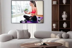 Plakat: Szczęśliwa sportsmenka słuchania muzyki i korzystania z smartphone