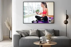 Plakat: Szczęśliwa sportsmenka słuchania muzyki i korzystania z smartphone