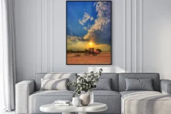 Plakat: Traktor na polu przed zachodem słońca