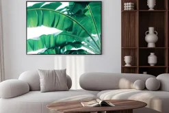 Plakat: Tropical green leaves pattern on white background, lush foliage